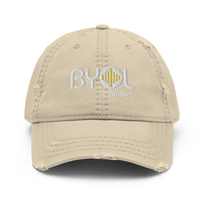 Khaki distressed dad hat with "BYOL a mindset" embroidered on the front in white and yellow, displayed against a clean background. Available in various colors: black, navy blue, gray, green, and beige.