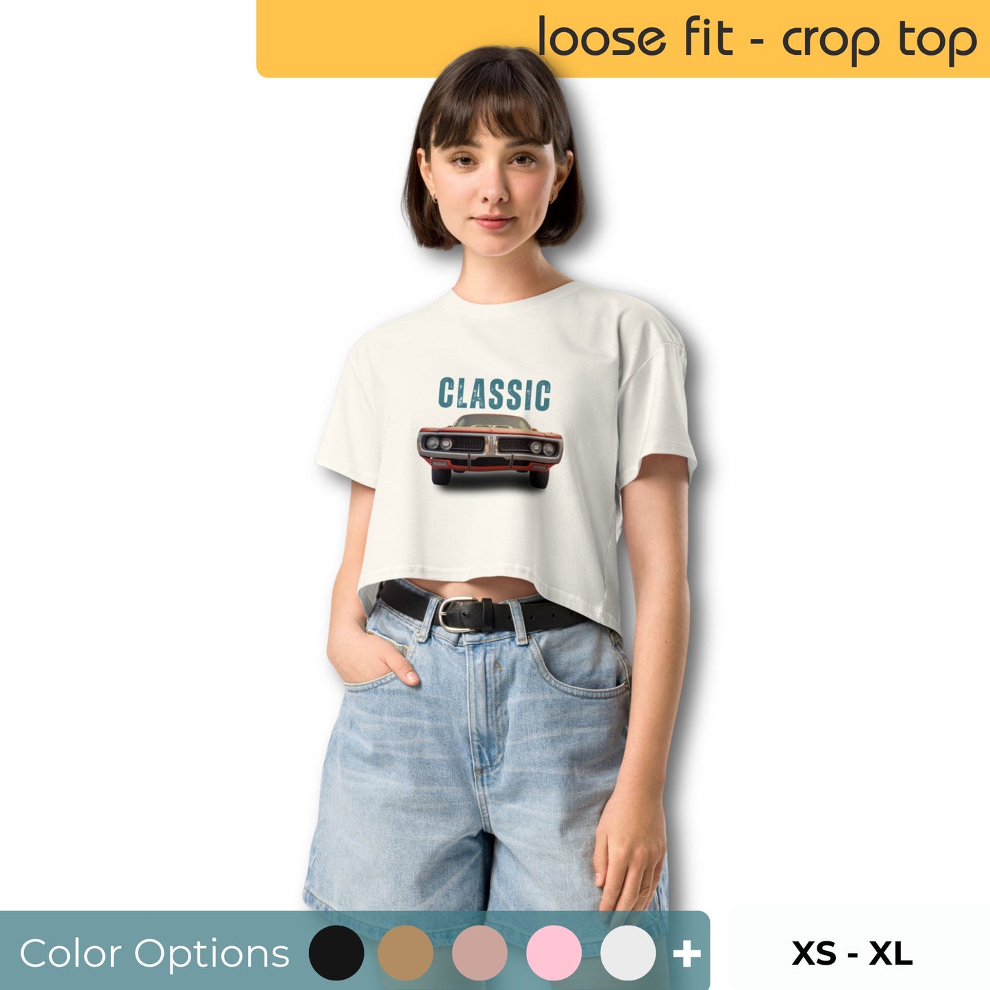 Confident young woman in a cream-colored loose-fit crop top with a 'CLASSIC' car graphic, paired with light-wash denim shorts and a variety of color options, representing sizes XS through XL.