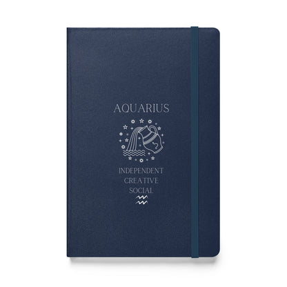 A blue hardcover notebook with 'AQUARIUS' and symbolic illustrations printed in white, along with the words 'INDEPENDENT CREATIVE SOCIAL'. The notebook features an elastic closure.