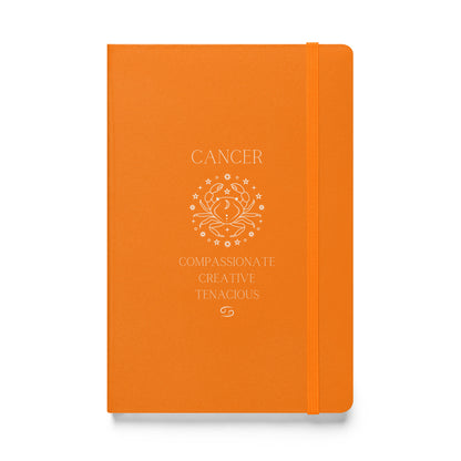 Orange hardcover notebook that says "cancer" at the top with the an image of the cancer animal followed by three caner traits and the cancer zodiac sign