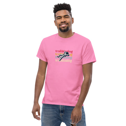 Smiling man in a pink classic tee with vibrant 'trailblazing' text, embodying the spirit of boldness and individual trailblazing attitude.