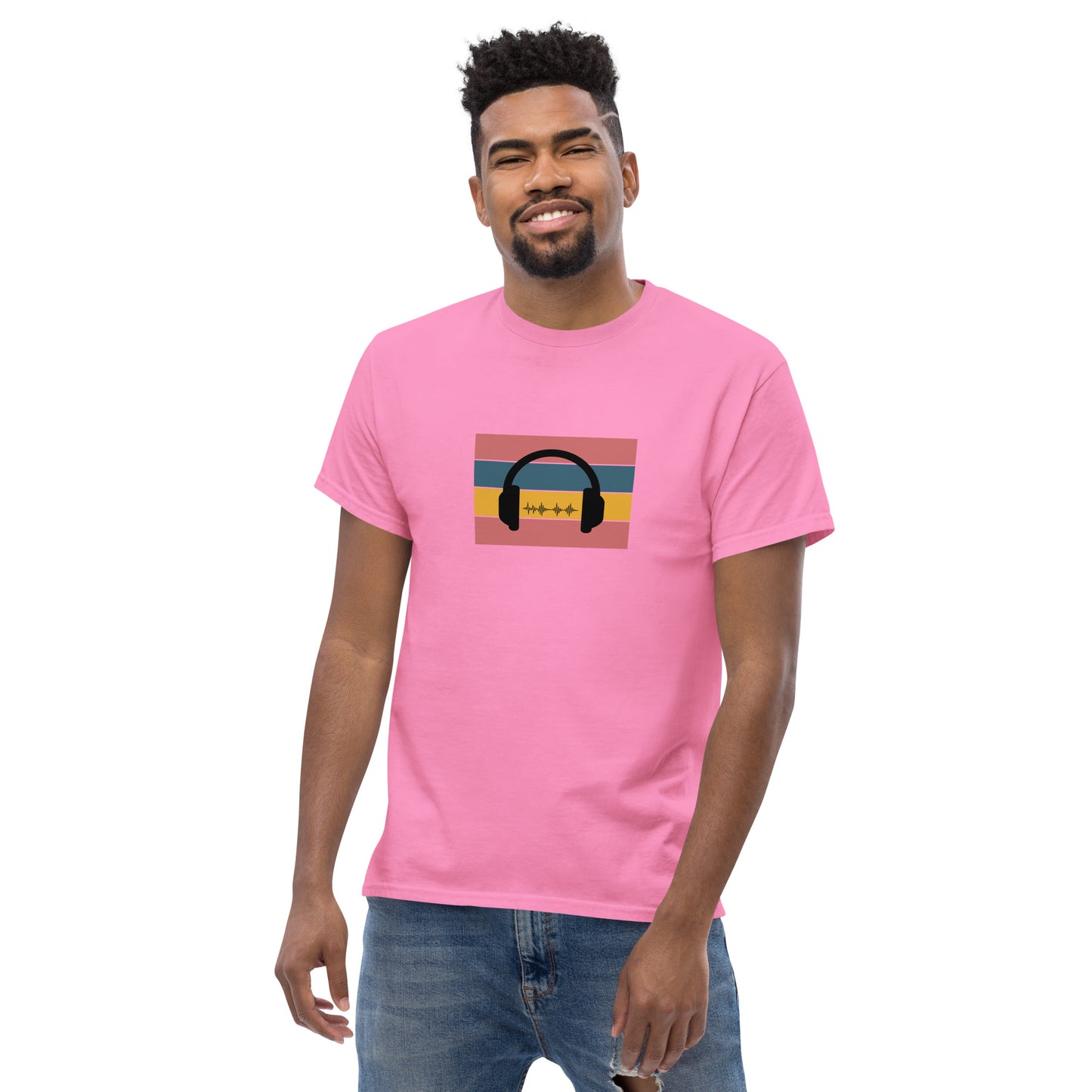 Man smiling in a pink classic tee featuring a sunset and skyline design with 'Life Is Good' text, symbolizing optimism and bold living.