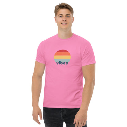 Confident man sporting a pink classic tee with a colorful retro sunset design and 'vibes' text, evoking a relaxed and inspiring mood.