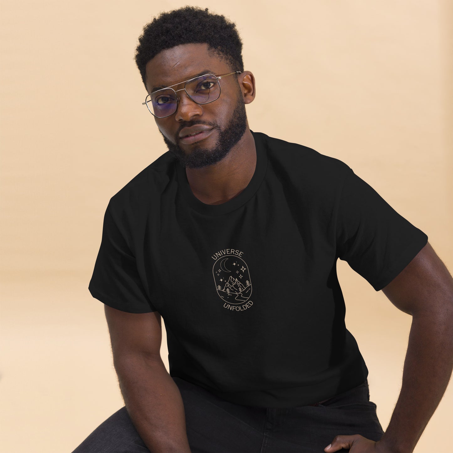 Man in a black tee with a cosmic design saying 'Universe Unfolded', epitomizing bold self-expression.