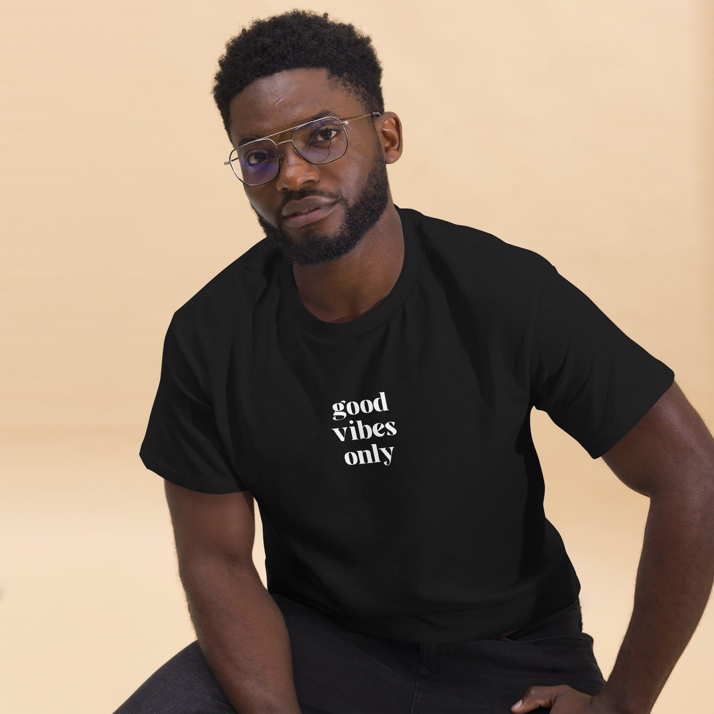 Man wearing a black classic tee with 'good vibes only' text, a testament to a lifestyle of positivity and authentic personal expression.