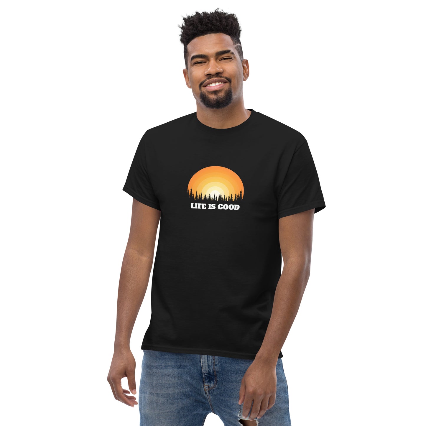 Happy man wearing a black classic tee with a vibrant sunset graphic and 'Life Is Good' slogan, inspiring positivity and joy.