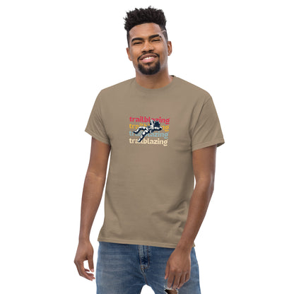 Smiling man in a brown savana classic tee with vibrant 'trailblazing' text, embodying the spirit of boldness and individual trailblazing attitude.