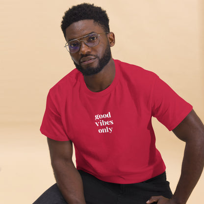 Man wearing a red classic tee with 'good vibes only' text, a testament to a lifestyle of positivity and authentic personal expression.