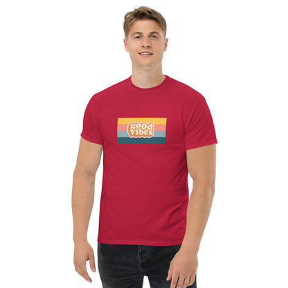 Smiling man wearing a cardinal red classic tee with a colorful 'good vibes' retro graphic, symbolizing relaxed and inspirational personal style.