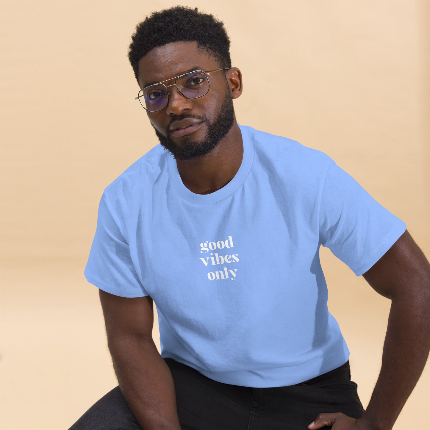 Man wearing a carolina blue classic tee with 'good vibes only' text, a testament to a lifestyle of positivity and authentic personal expression.