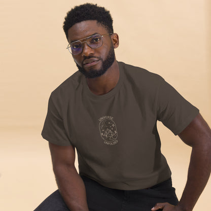 Man in a chocolate tee with a cosmic design saying 'Universe Unfolded', epitomizing bold self-expression.