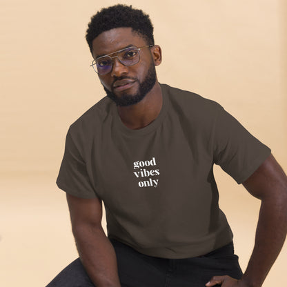 Man wearing a dark chocolate classic tee with 'good vibes only' text, a testament to a lifestyle of positivity and authentic personal expression.