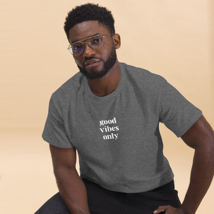 Man wearing a heather grey classic tee with 'good vibes only' text, a testament to a lifestyle of positivity and authentic personal expression.