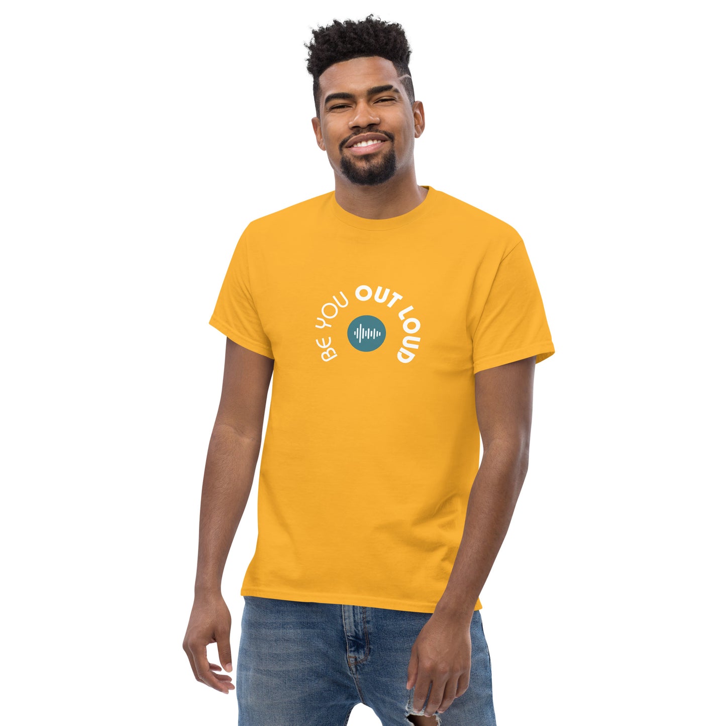 Man smiling in a yellow classic tee featuring the 'Be You Out Loud' white and blue logo on the front