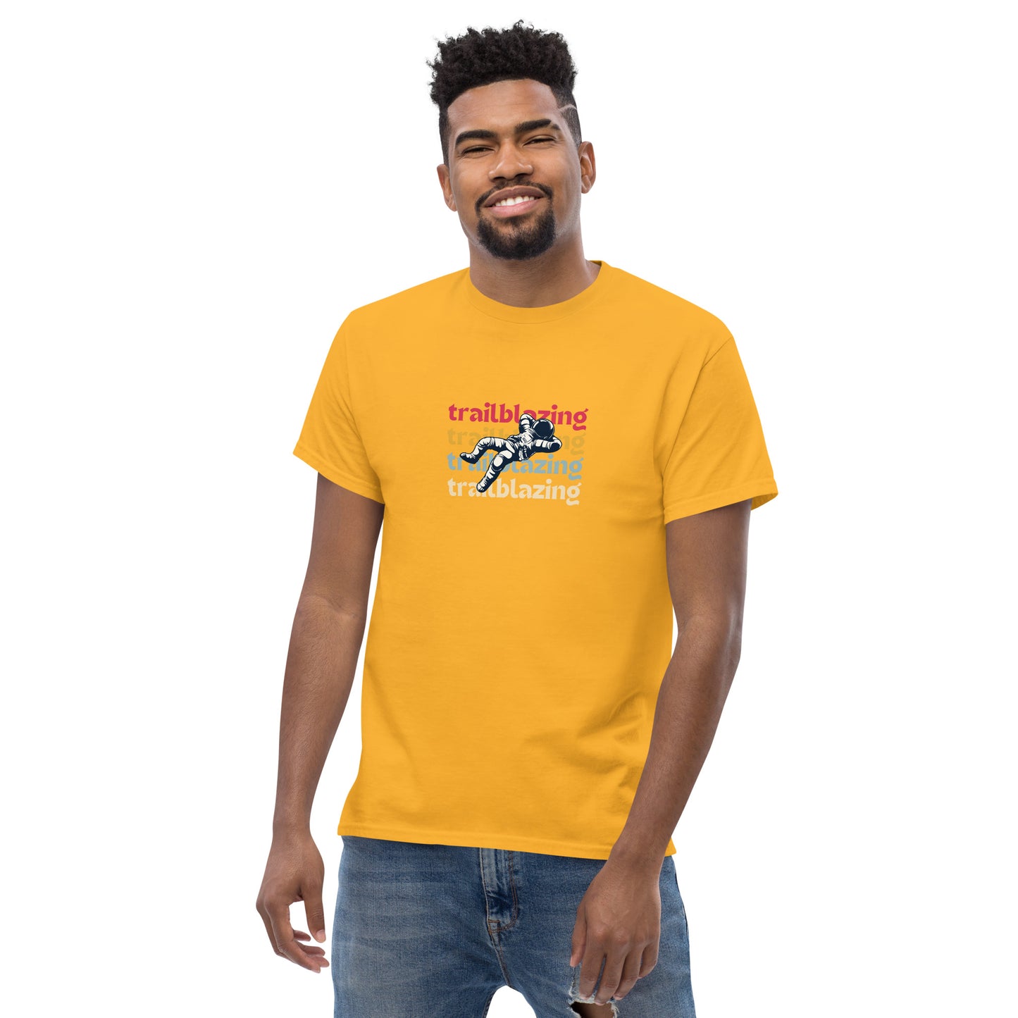 Smiling man in a yellow classic tee with vibrant 'trailblazing' text, embodying the spirit of boldness and individual trailblazing attitude.