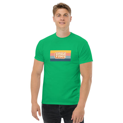 Smiling man wearing a irish green  classic tee with a colorful 'good vibes' retro graphic, symbolizing relaxed and inspirational personal style.