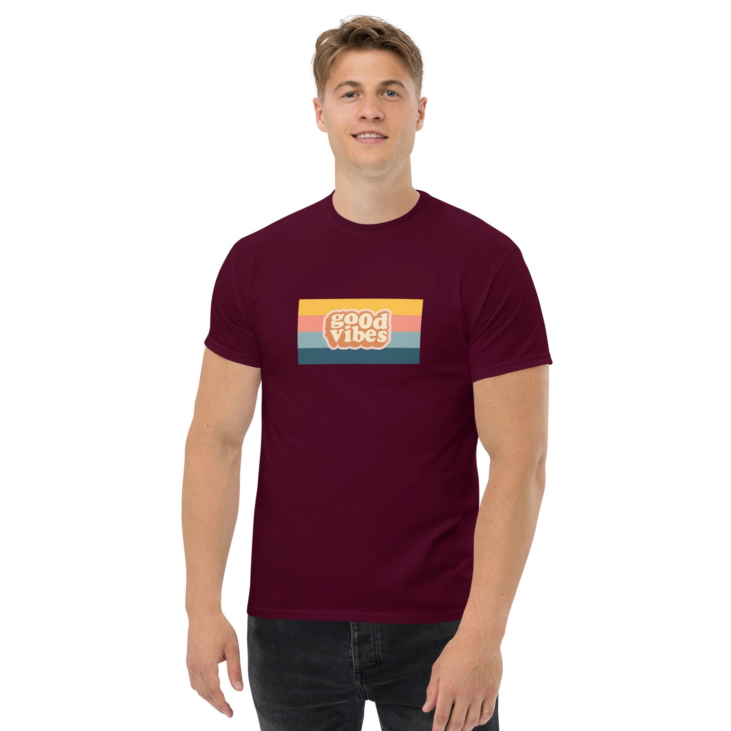 Smiling man wearing a maroon classic tee with a colorful 'good vibes' retro graphic, symbolizing relaxed and inspirational personal style.