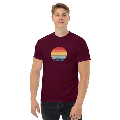 Confident man sporting a maroon classic tee with a colorful retro sunset design and 'vibes' text, evoking a relaxed and inspiring mood.