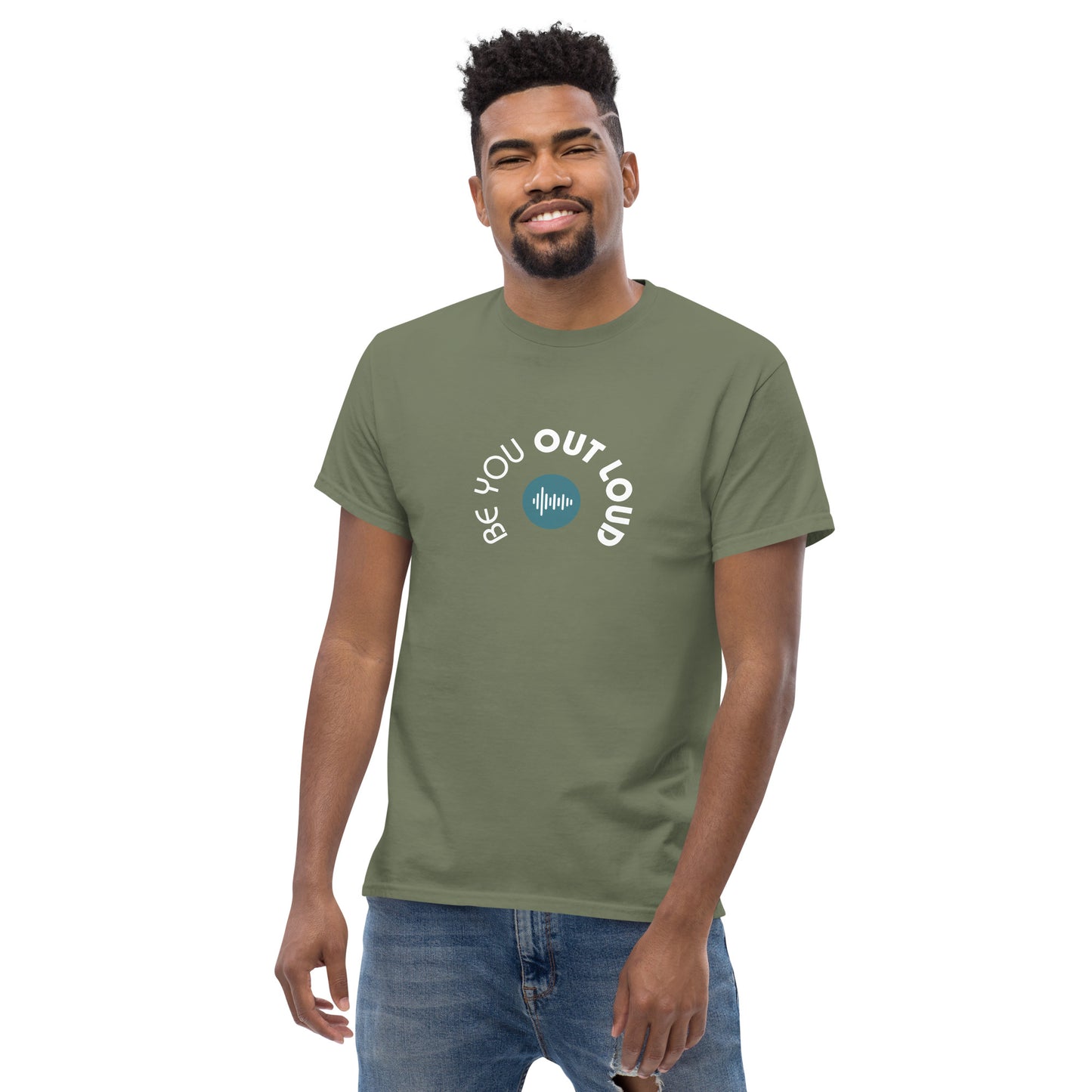 Man smiling in a hunter green classic tee featuring the 'Be You Out Loud' white and blue logo on the front