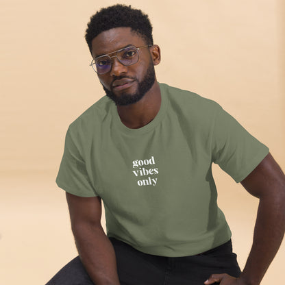 Man wearing a military green classic tee with 'good vibes only' text, a testament to a lifestyle of positivity and authentic personal expression.