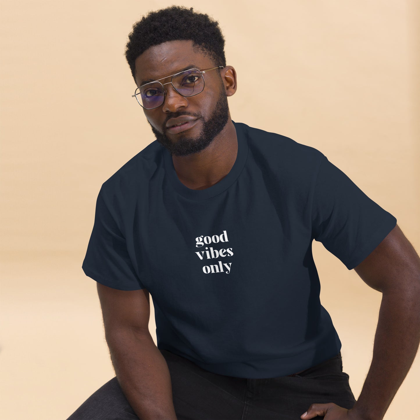 Man wearing a navy blue classic tee with 'good vibes only' text, a testament to a lifestyle of positivity and authentic personal expression.