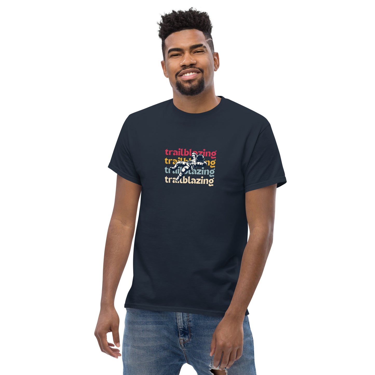 Smiling man in a navy blue classic tee with vibrant 'trailblazing' text, embodying the spirit of boldness and individual trailblazing attitude.