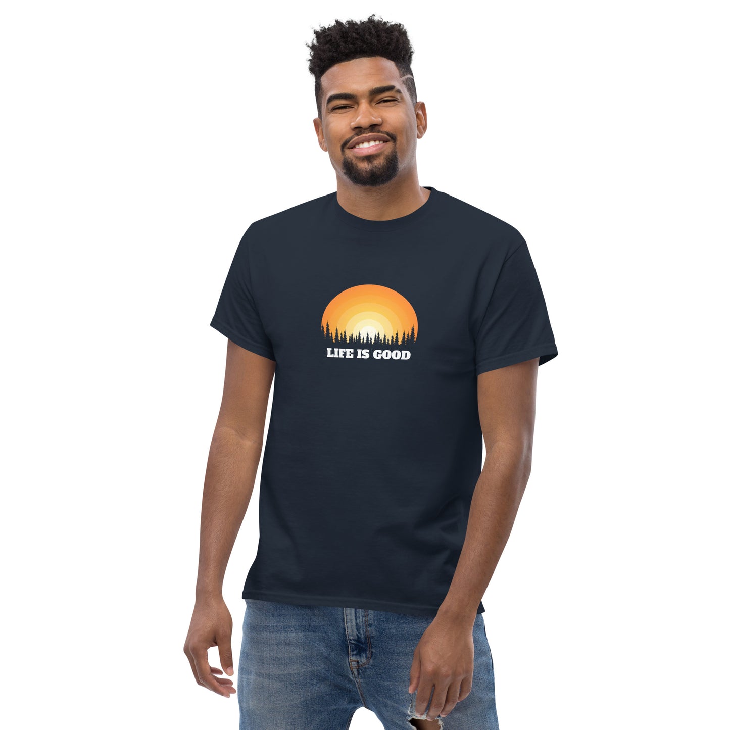 Happy man wearing a navy blue classic tee with a vibrant sunset graphic and 'Life Is Good' slogan, inspiring positivity and joy.