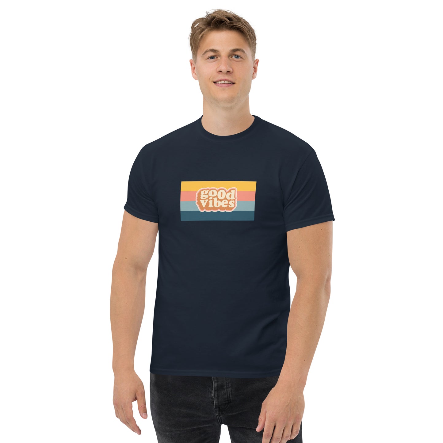 Smiling man wearing a navy blue classic tee with a colorful 'good vibes' retro graphic, symbolizing relaxed and inspirational personal style.