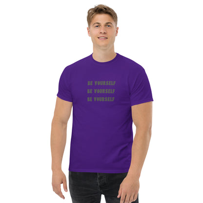 Smiling man in a purple classic tee with 'BE YOURSELF' text fading vertically, echoing authenticity and personal expression.