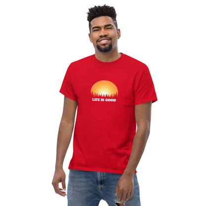 Happy man wearing a cardinal red classic tee with a vibrant sunset graphic and 'Life Is Good' slogan, inspiring positivity and joy.