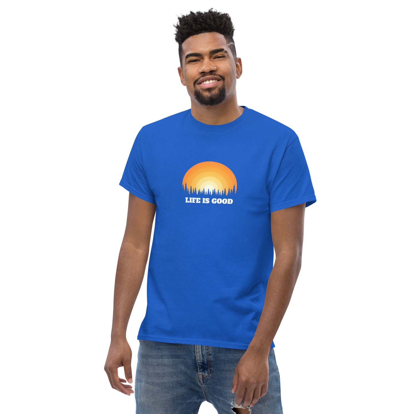 Happy man wearing a royal blue classic tee with a vibrant sunset graphic and 'Life Is Good' slogan, inspiring positivity and joy.