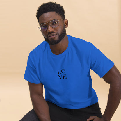 Man in royal blue t-shirt with "LOVE" print leaning forward against a light background, portraying casual style and positive messaging.