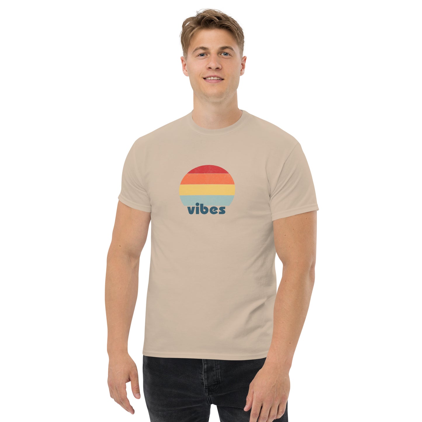 Confident man sporting a sand classic tee with a colorful retro sunset design and 'vibes' text, evoking a relaxed and inspiring mood.