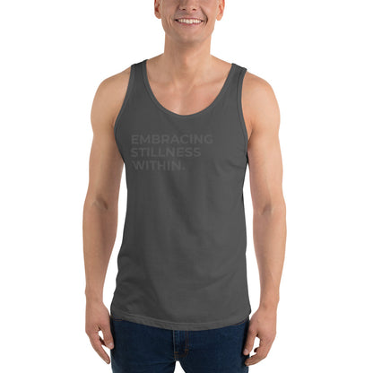 Man wearing a asphalt sleeveless tank with "Embracing Stillness Within" text. 