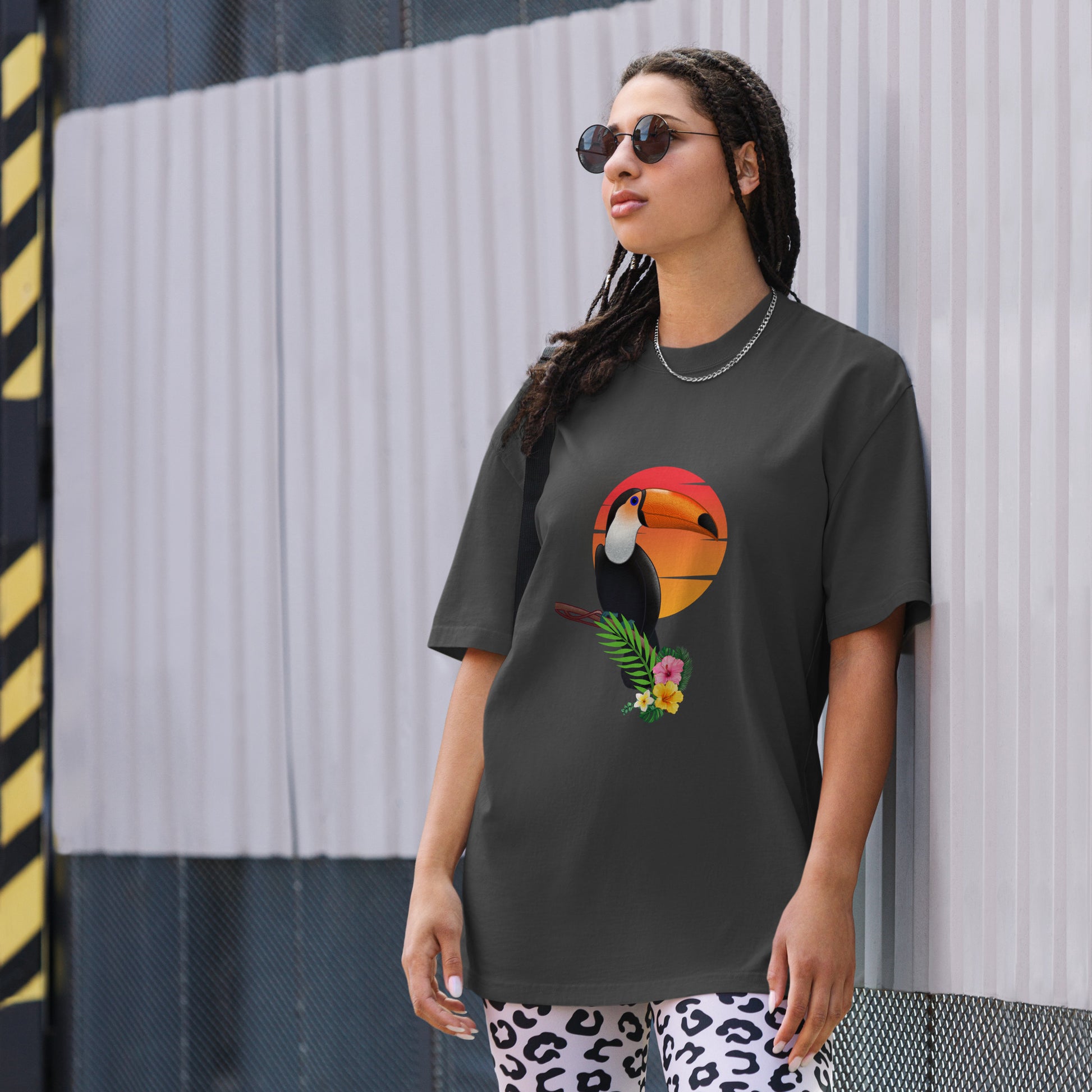 Woman in a faded black oversized tee with colorful toucan graphic design, symbolizing vibrant self-expression.