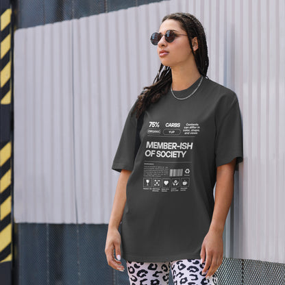 A woman models a Women's 'Member-ish of Society' faded black Oversized Tee, featuring a humorous, nutrition-fact-style graphic. Tee is paired with a subtle chain necklace and cool sunglasses, adding a touch of irony to casual wear. 