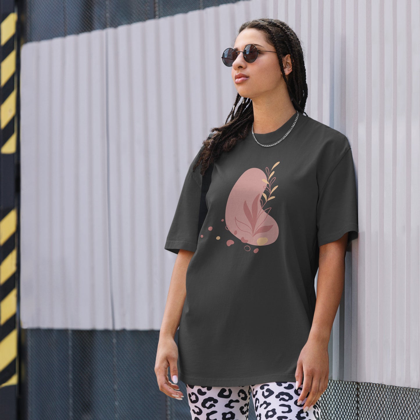 Woman wearing a black oversized faded tee with a bold heart design, showcasing self-expression and fearless fashion