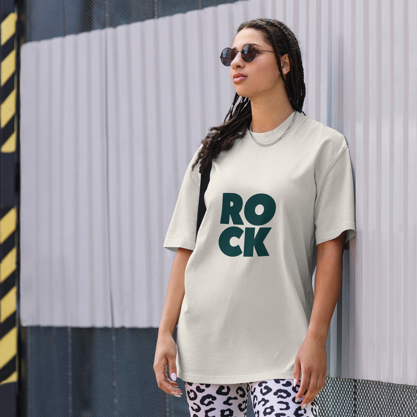 Confident individual rocking a bold faded bone oversized graphic tee with an oversized, faded ROCK design, embodying fearless self-expression.