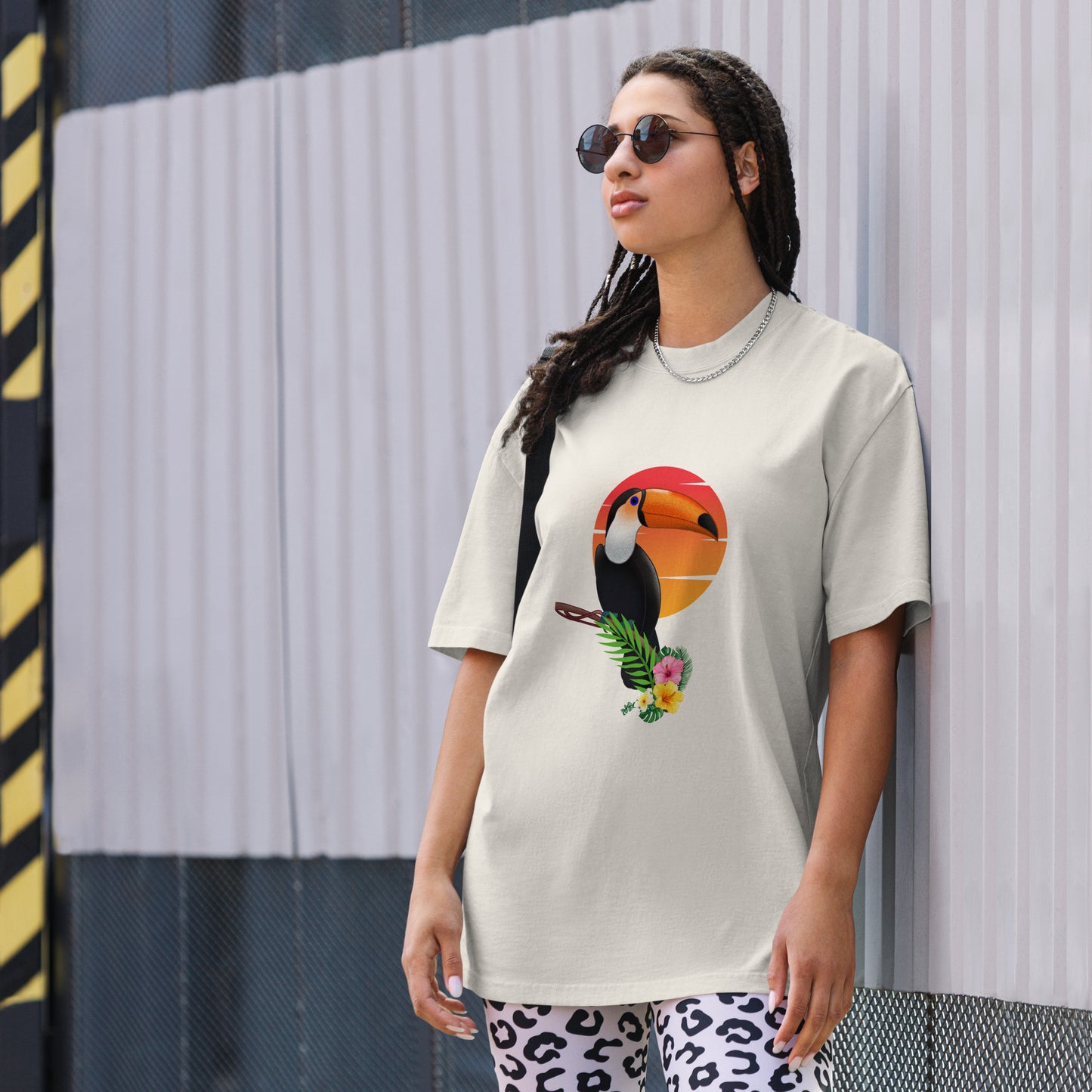 Woman in a faded bone oversized tee with colorful toucan graphic design, symbolizing vibrant self-expression.