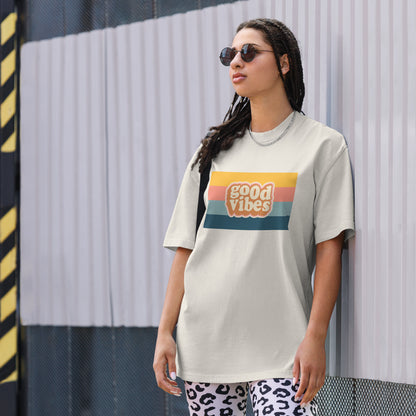 Woman in a trendy graphic faded bone tee with a retro sunset design that reads 'good vibes', exuding a casual, cool attitude.