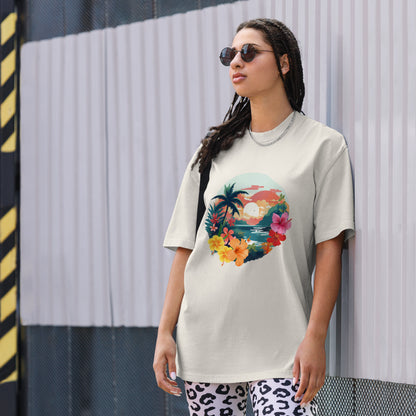 Fashion-forward woman in a Women's Tropical Sunset faded bone Oversized Tee featuring a vibrant, artistic print of palm trees and flowers, paired with statement leopard print pants and chic sunglasses, encapsulating a fresh, summery aesthetic.