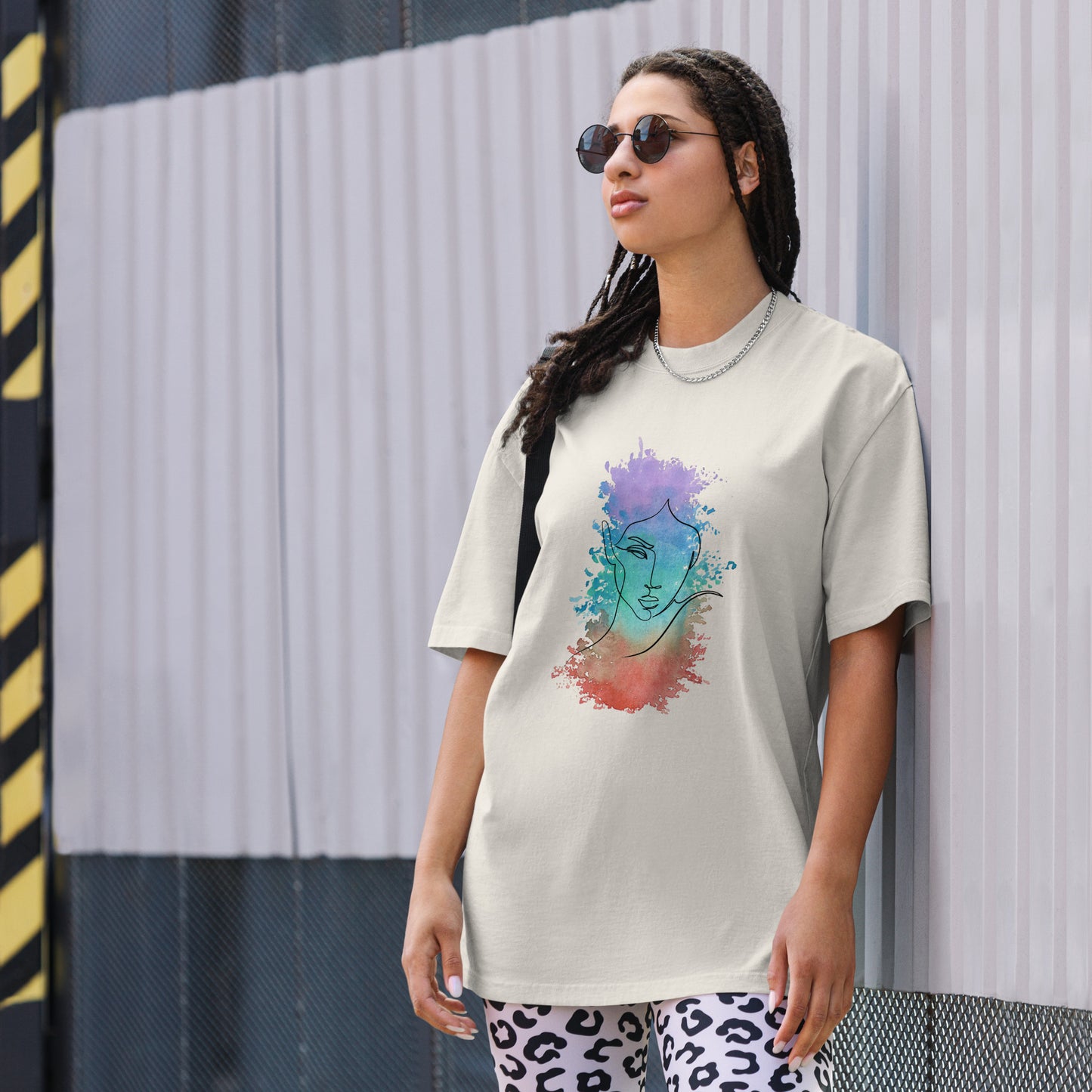 Woman in a faded bone oversized tee showcasing a vibrant artistic face design, reflecting Be You Out Loud’s celebration of individuality and self-expression.