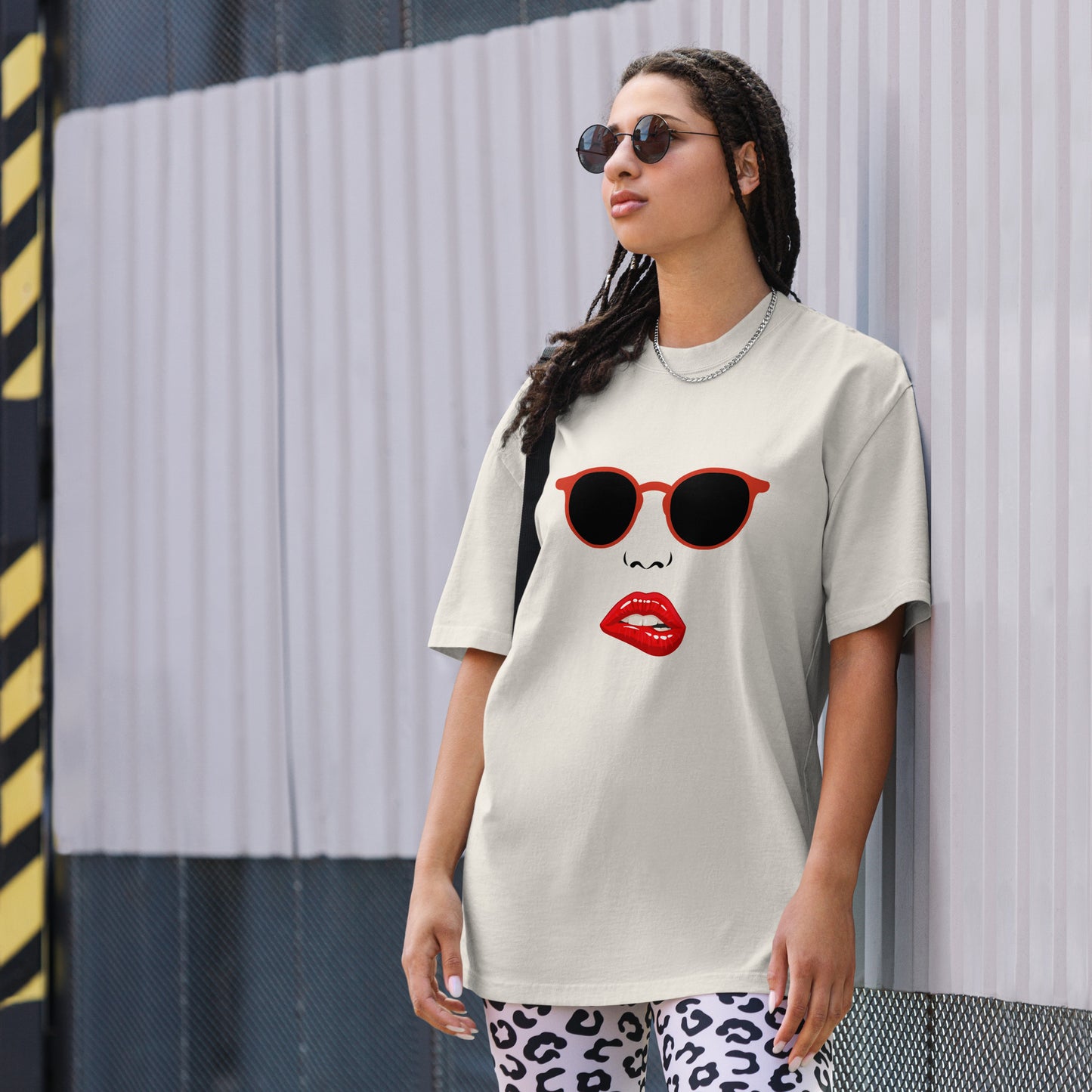 Woman wearing a Women's Quirky Retro Red Specs faded bone Oversized Graphic Tee, embodying cool self-expression with a touch of retro charm.