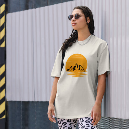 Fashion-forward woman in a Women's Sunset Mountains Lifestyle faded bone Tee against an urban backdrop, echoing the adventure of Be You Out Loud.