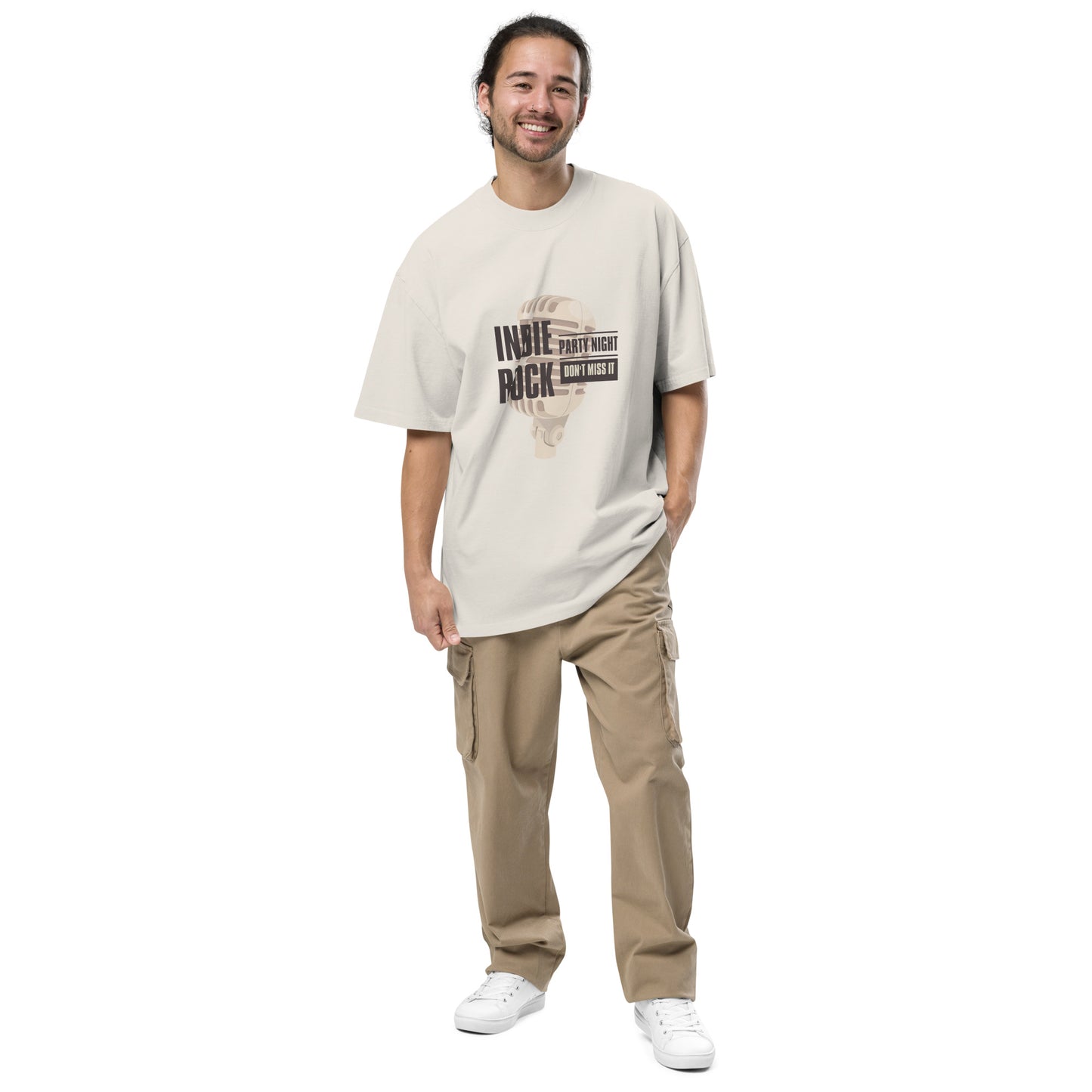 Smiling man in Men's "Indie Night Rich" faded bone Oversized Graphic Tee in khaki, perfect for partygoers and indie music lovers.