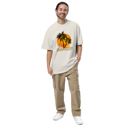 Cheerful man in Men's "Tropical Simplicity" Vintage faded bone Oversized Tee featuring a palm tree silhouette against an orange backdrop, capturing the essence of relaxed style