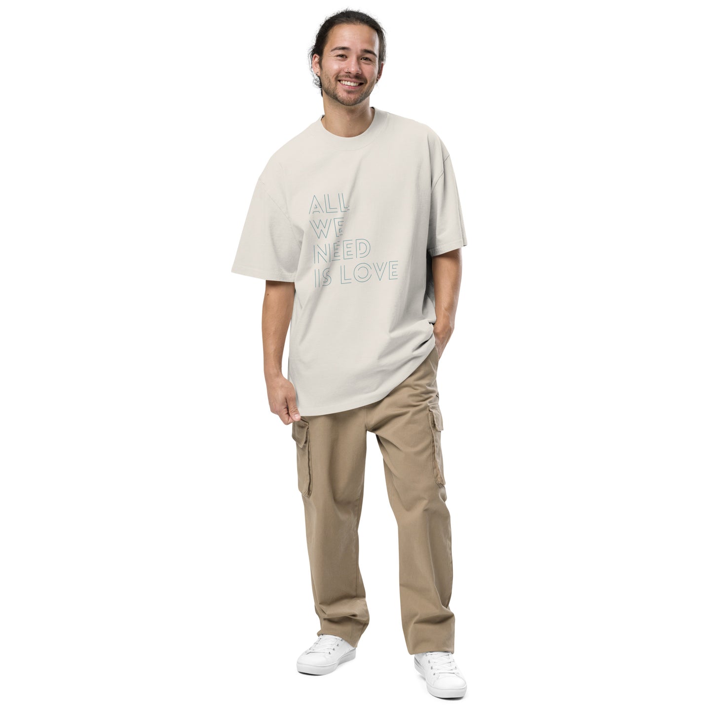 Content man in a Men's "All We Need is Love" faded bone Oversized Tee by, evoking casual style and positive vibes.