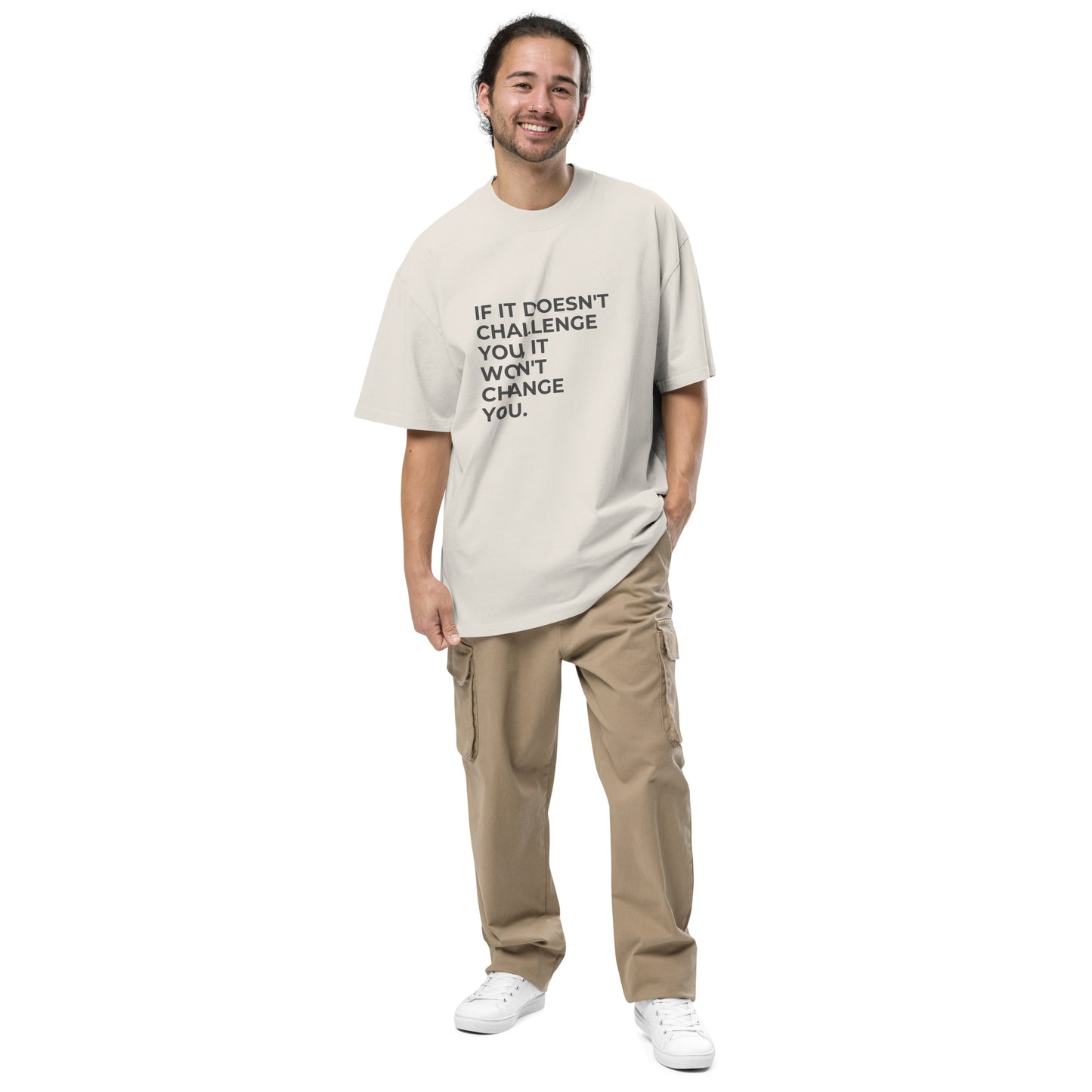 Man wearing a faded bone oversized faded tee in light beige with "If It Doesn’t Challenge You, It Won’t Change You" text. 