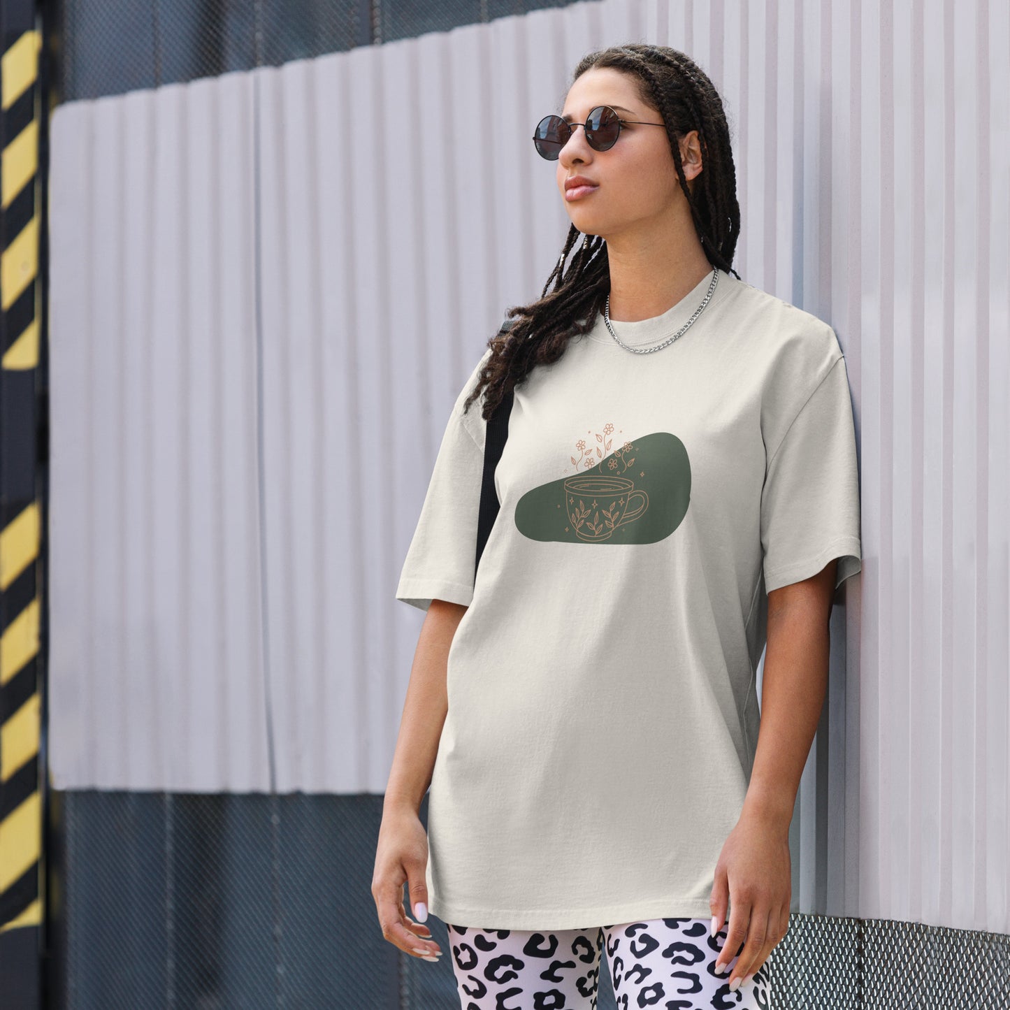 Woman wearing a faded bone oversized faded tee with a whimsical tea cup design, highlighting playful self-expression and bold fashion.