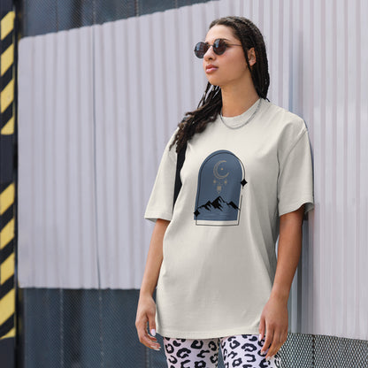 Woman wearing a faded bone oversized faded tee with a dreamy mountain night design, showcasing unique self-expression and bold fashion.